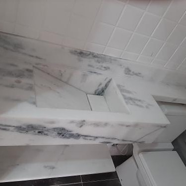 Detalhe de cuba esculpida em mármore cinza para lavabo