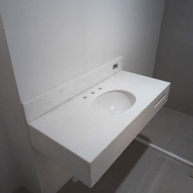 Detalhe de cuba de banheiro esculpida em mármore branco